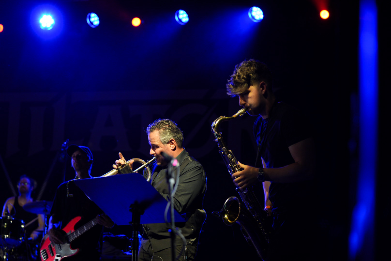 On stage with the band under blue and red light
