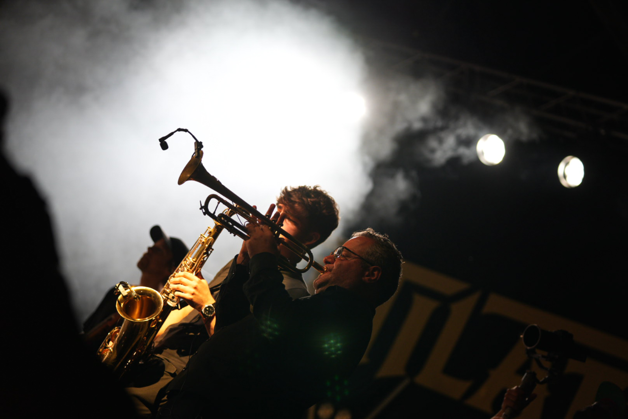 Backlit in the spotlight, saxophone raised