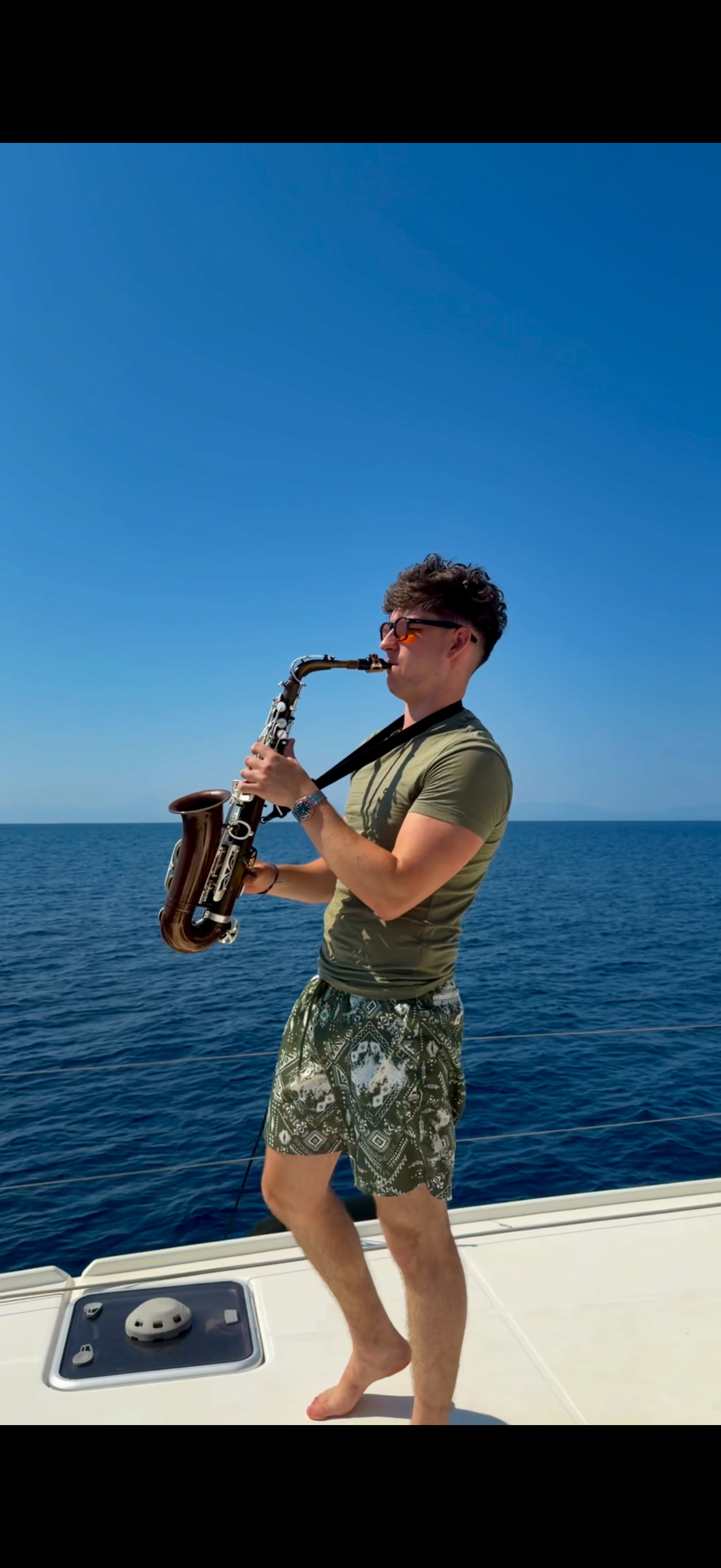Playing at the rail with the sea behind