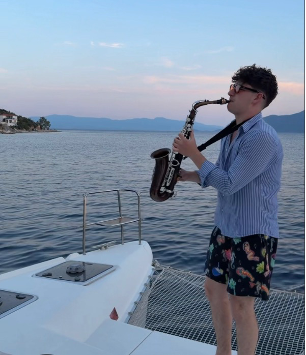Playing saxophone on the deck of a boat at sea